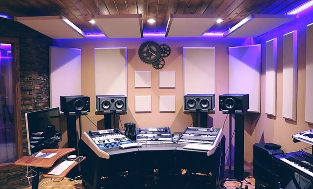 Studio with sound mixer, speakers and acoustic panels on wall and ceiling