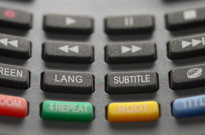 Close-up of subtitle button a grey remote control