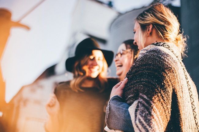 3 women chatting and laughing with each other outside