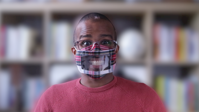 Ahmed Khalifa wearing a tartan-coloured clear face-mask and smiling (which you can see)