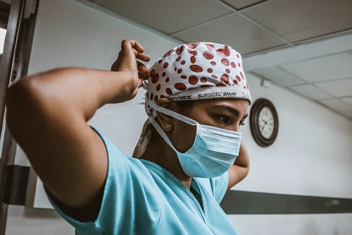 Doctor tying face mask in a hospital